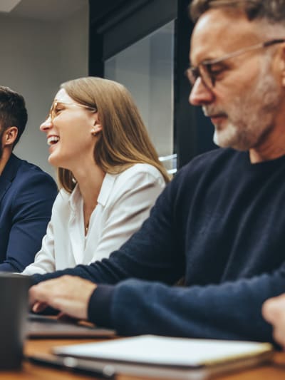 Four people sit at a conference room table.